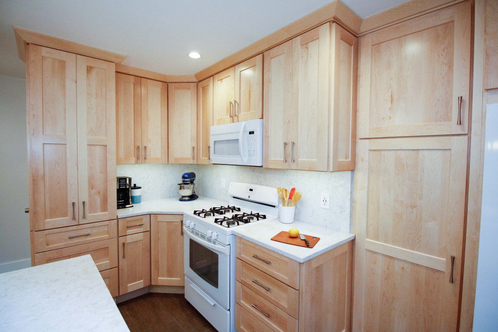 Exempel på ett mellanstort modernt vit vitt kök, med en undermonterad diskho, skåp i shakerstil, skåp i ljust trä, bänkskiva i kvarts, vitt stänkskydd, vita vitvaror, klinkergolv i porslin, en köksö och brunt golv