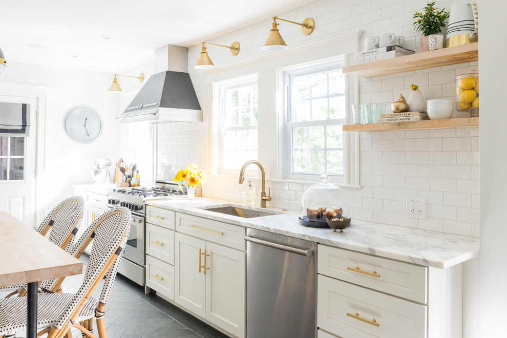 Foto di una piccola cucina moderna con lavello sottopiano, ante bianche, top in marmo, paraspruzzi bianco, paraspruzzi con piastrelle diamantate, elettrodomestici in acciaio inossidabile e pavimento in ardesia