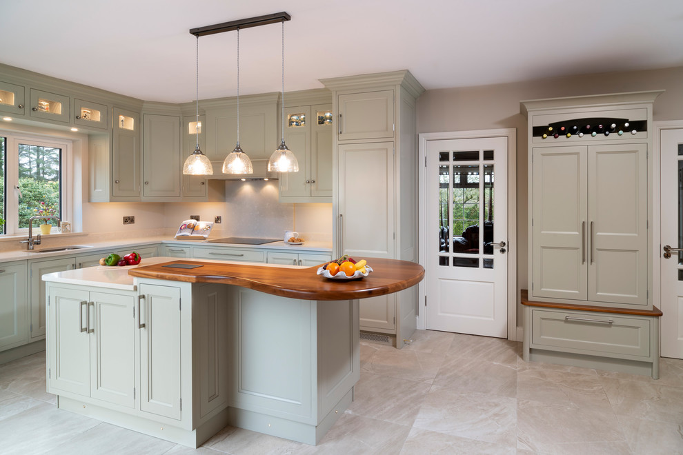 Design ideas for a medium sized country l-shaped kitchen/diner in Cork with a double-bowl sink, flat-panel cabinets, green cabinets, quartz worktops, beige splashback, stainless steel appliances, porcelain flooring, an island, beige floors and beige worktops.