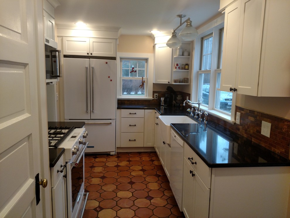 Small country galley terra-cotta tile enclosed kitchen photo in Boston with a farmhouse sink, shaker cabinets, white cabinets, quartz countertops, metallic backsplash and white appliances