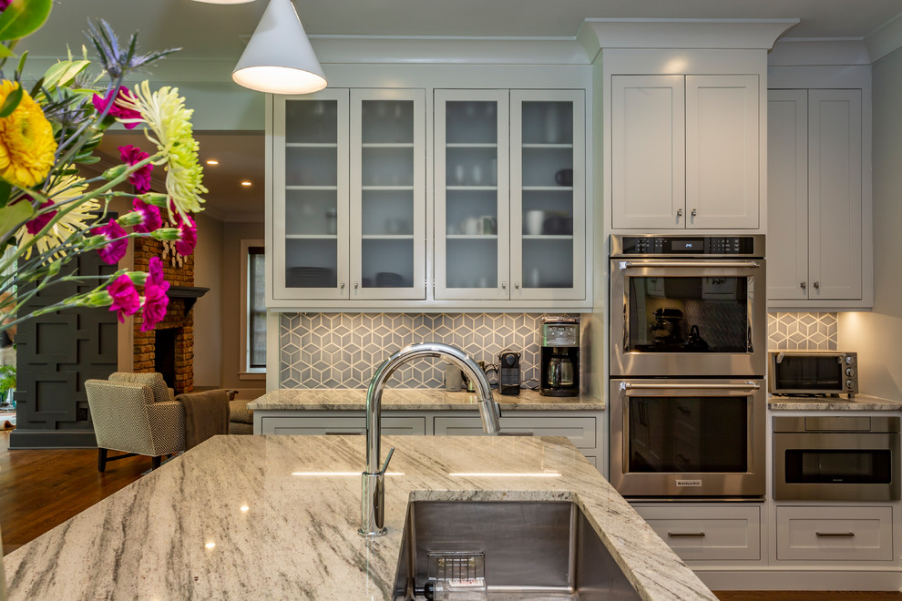 Exempel på ett stort klassiskt flerfärgad flerfärgat kök, med en undermonterad diskho, luckor med infälld panel, grå skåp, marmorbänkskiva, blått stänkskydd, stänkskydd i porslinskakel, rostfria vitvaror, mellanmörkt trägolv, en köksö och brunt golv