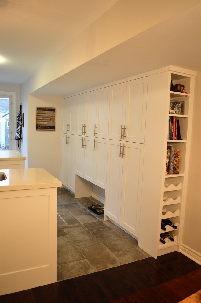 Medium sized classic u-shaped kitchen pantry in Toronto with a double-bowl sink, shaker cabinets, white cabinets, quartz worktops, ceramic splashback, stainless steel appliances, ceramic flooring, an island, grey floors and white worktops.