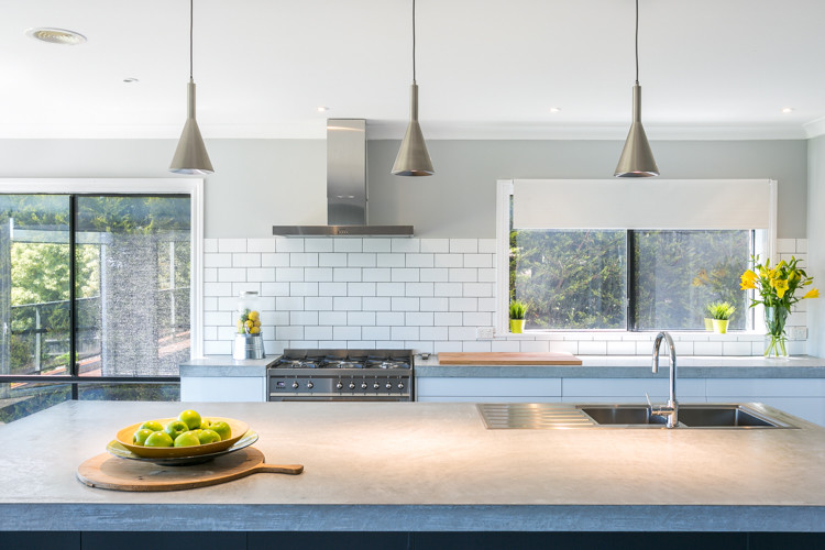 Inspiration for an expansive contemporary galley kitchen/diner in Melbourne with a double-bowl sink, open cabinets, white cabinets, concrete worktops, white splashback, metro tiled splashback, stainless steel appliances and an island.