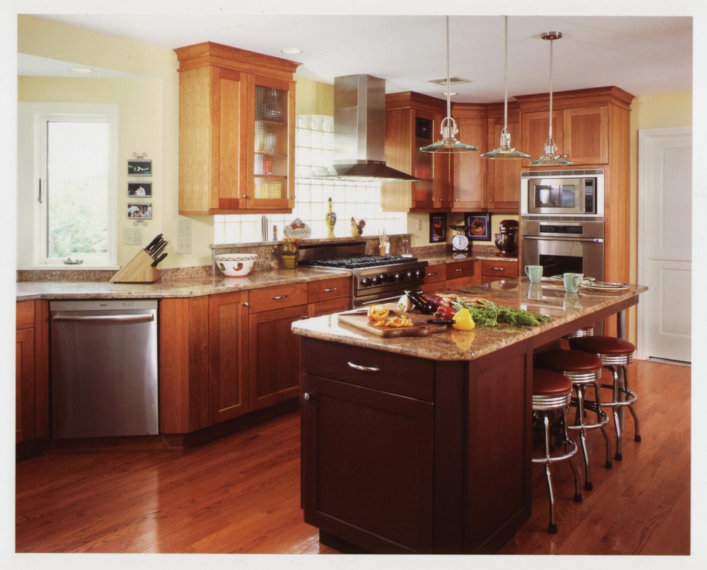 Example of a trendy u-shaped eat-in kitchen design in Bridgeport with stainless steel appliances, granite countertops, an undermount sink, flat-panel cabinets, dark wood cabinets and stone slab backsplash