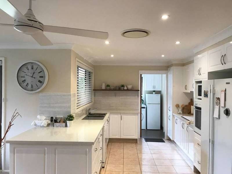 Example of a mid-sized country u-shaped pink floor eat-in kitchen design in Sydney with a double-bowl sink, shaker cabinets, white cabinets, quartzite countertops, gray backsplash, white appliances and no island