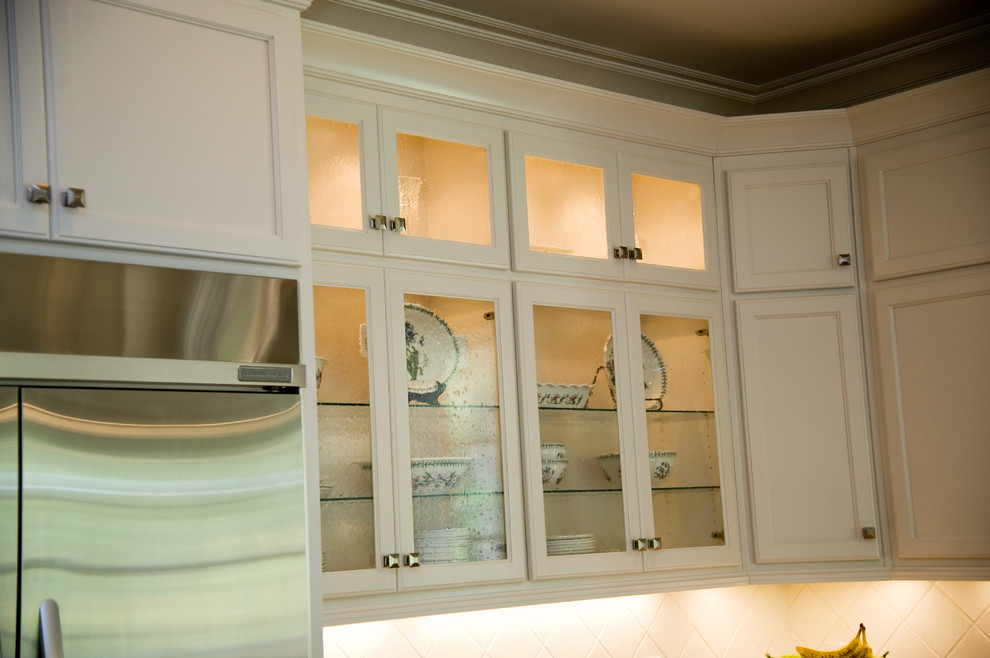 Imagen de cocina comedor clásica de tamaño medio con armarios tipo vitrina, puertas de armario blancas y una isla