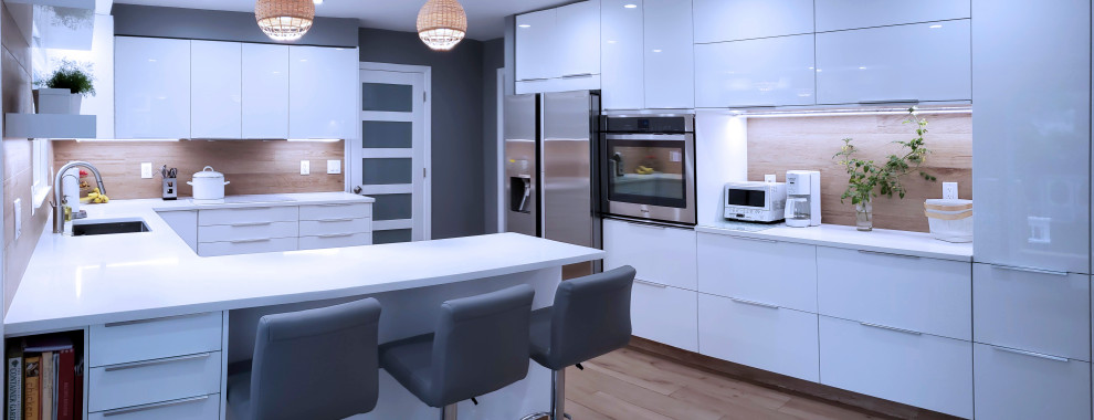 Photo of a medium sized modern u-shaped enclosed kitchen in New York with a submerged sink, flat-panel cabinets, white cabinets, engineered stone countertops, brown splashback, porcelain splashback, stainless steel appliances, porcelain flooring, a breakfast bar, brown floors and white worktops.