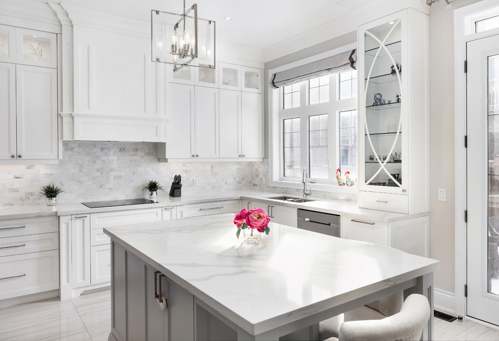This is an example of a large traditional u-shaped open plan kitchen in Toronto with a submerged sink, shaker cabinets, white cabinets, engineered stone countertops, grey splashback, mosaic tiled splashback, stainless steel appliances, ceramic flooring, an island, grey floors and white worktops.