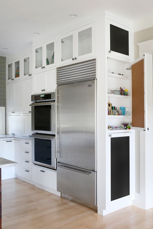 Kleine Urige Küche in U-Form mit Landhausspüle, Kassettenfronten, weißen Schränken, Granit-Arbeitsplatte, Küchengeräten aus Edelstahl und hellem Holzboden in Boston