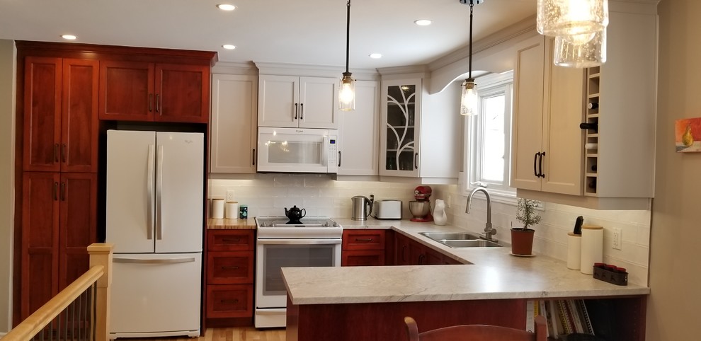 Mid-sized transitional u-shaped light wood floor and yellow floor eat-in kitchen photo in Other with a double-bowl sink, shaker cabinets, medium tone wood cabinets, laminate countertops, white backsplash, subway tile backsplash, white appliances, a peninsula and beige countertops