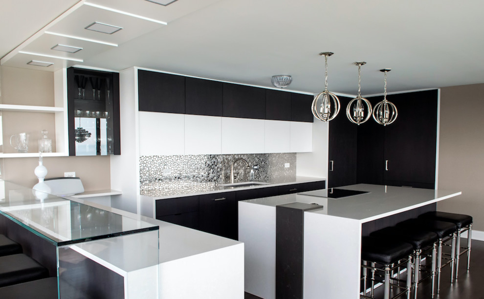 This is an example of a large modern u-shaped open plan kitchen in Chicago with a double-bowl sink, flat-panel cabinets, white cabinets, multi-coloured splashback, stainless steel appliances, dark hardwood flooring, an island, brown floors, engineered stone countertops, metal splashback and white worktops.