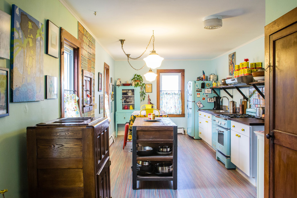 Cette photo montre une cuisine linéaire éclectique fermée avec des portes de placard blanches, une crédence multicolore, un électroménager de couleur et îlot.