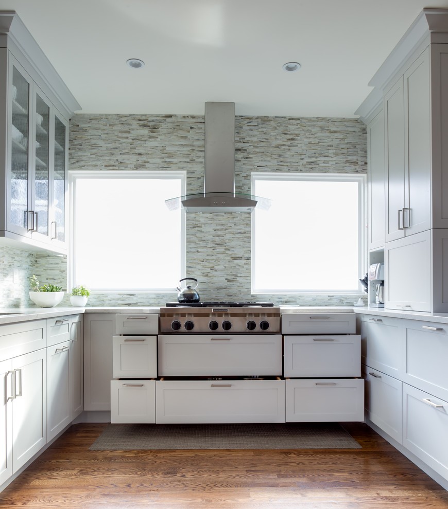Example of a mid-sized trendy u-shaped enclosed kitchen design in Denver with shaker cabinets, white cabinets and a peninsula