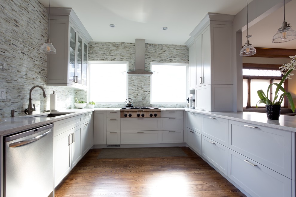 Cette photo montre une cuisine tendance en U fermée et de taille moyenne avec un placard à porte shaker, des portes de placard blanches et une péninsule.