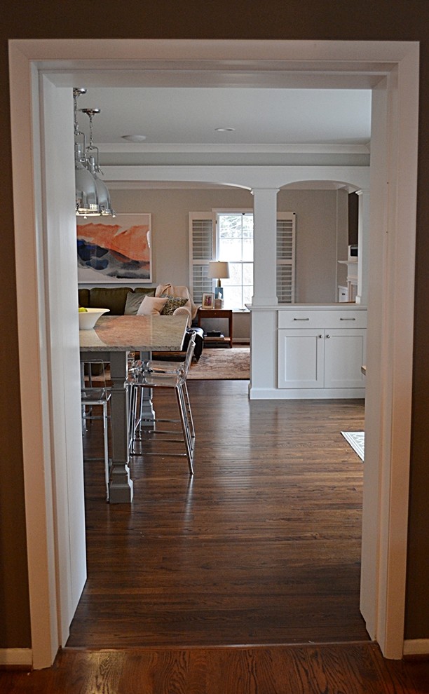 Inspiration pour une grande cuisine traditionnelle en L fermée avec un évier encastré, un placard à porte shaker, des portes de placard blanches, un plan de travail en granite, un électroménager en acier inoxydable, îlot, une crédence grise, une crédence en carreau de verre, parquet foncé et un sol marron.