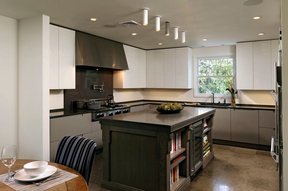 Diseño de cocina actual con armarios con paneles lisos, puertas de armario grises, salpicadero verde, electrodomésticos de acero inoxidable y salpicadero de losas de piedra