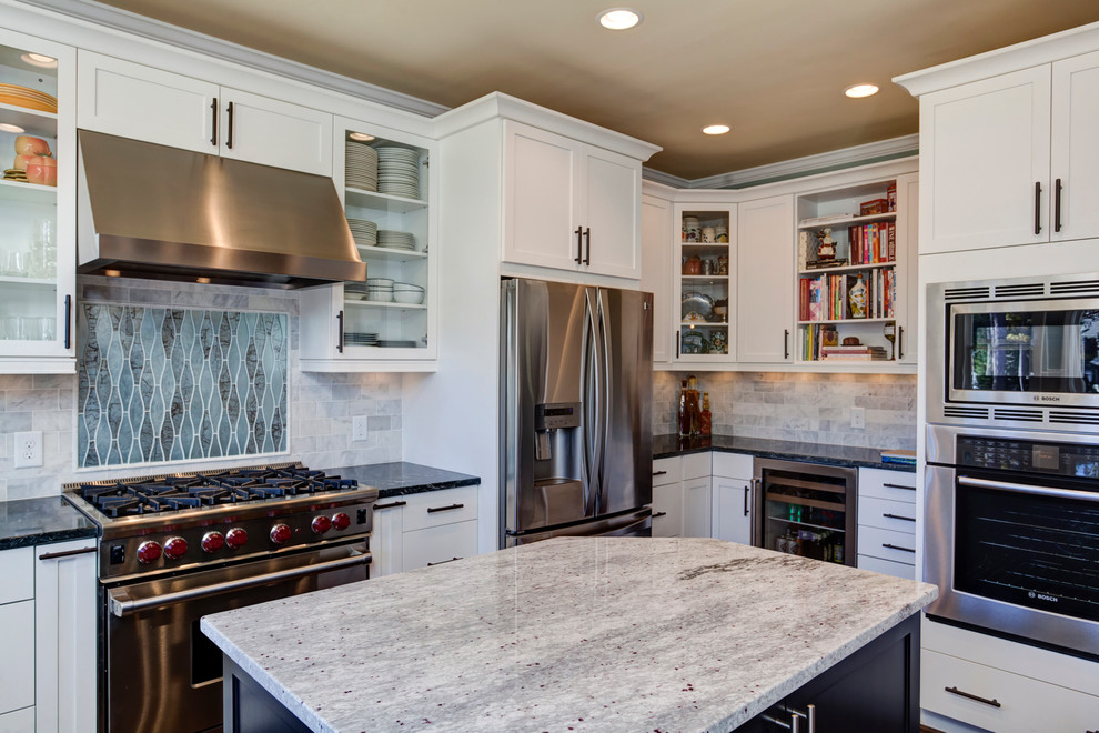 Traditional kitchen in Atlanta with shaker cabinets, white cabinets, multi-coloured splashback, stone tiled splashback and stainless steel appliances.