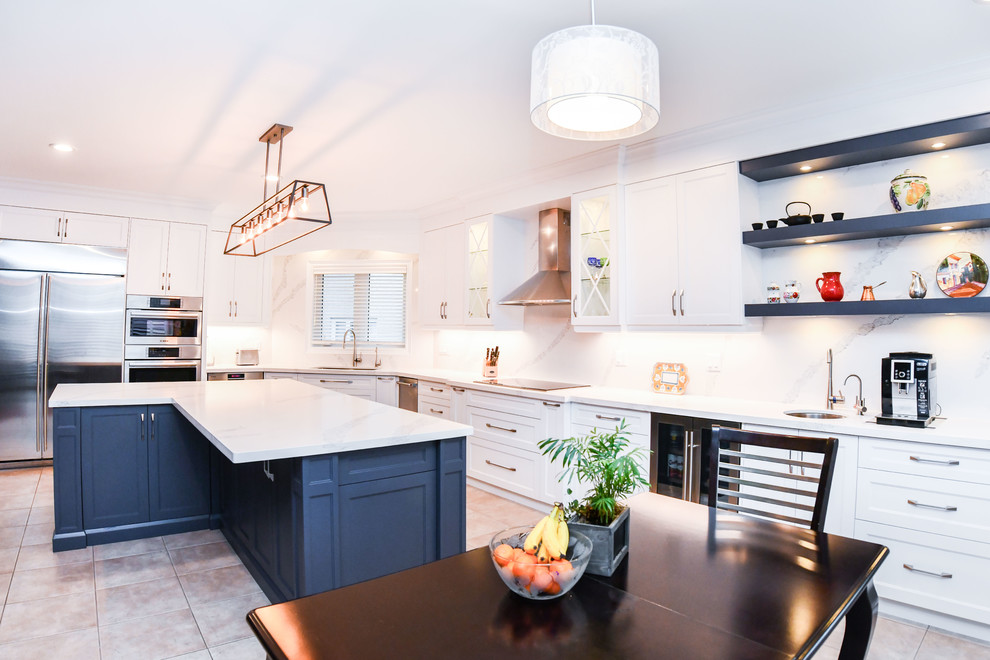 Immagine di una cucina chic con lavello sottopiano, ante in stile shaker, ante grigie, paraspruzzi bianco, elettrodomestici in acciaio inossidabile, pavimento beige e top bianco