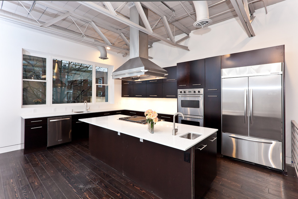 Пример оригинального дизайна: кухня в стиле лофт с плоскими фасадами, темными деревянными фасадами и техникой из нержавеющей стали