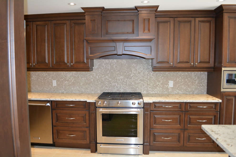 Exempel på ett mellanstort klassiskt kök, med en undermonterad diskho, luckor med upphöjd panel, rostfria vitvaror, klinkergolv i porslin, en köksö, skåp i mörkt trä, beige stänkskydd och stänkskydd i stenkakel