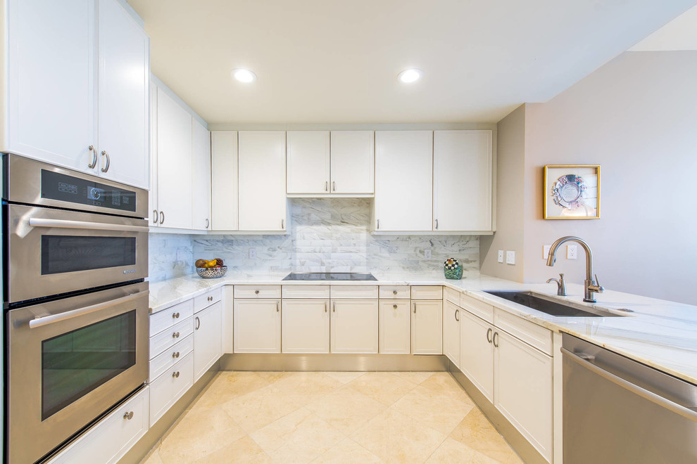 Small traditional u-shaped kitchen/diner in Miami with a submerged sink, flat-panel cabinets, white cabinets, marble worktops, white splashback, stone tiled splashback, stainless steel appliances, marble flooring and a breakfast bar.