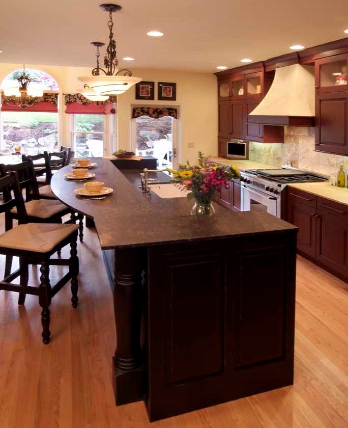 Example of a classic galley open concept kitchen design in Portland with a farmhouse sink, raised-panel cabinets, red cabinets, granite countertops, yellow backsplash, stone tile backsplash and paneled appliances