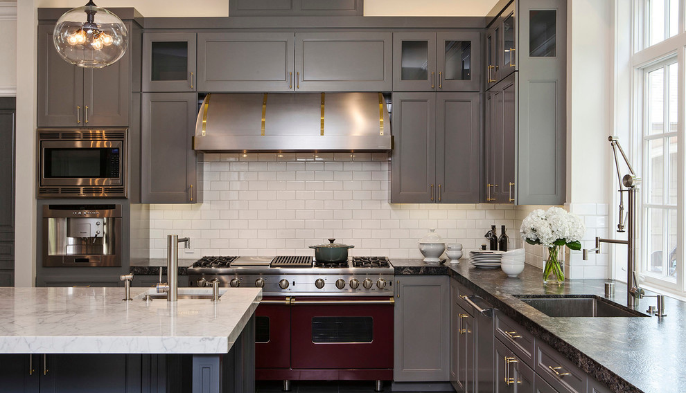 Bild på ett vintage l-kök, med en undermonterad diskho, luckor med infälld panel, grå skåp, vitt stänkskydd, stänkskydd i tunnelbanekakel, färgglada vitvaror och en köksö