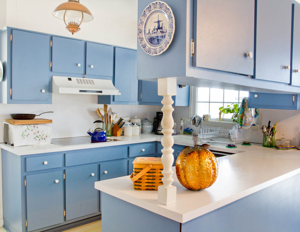 Пример оригинального дизайна: кухня в классическом стиле с синими фасадами и шторами на окнах