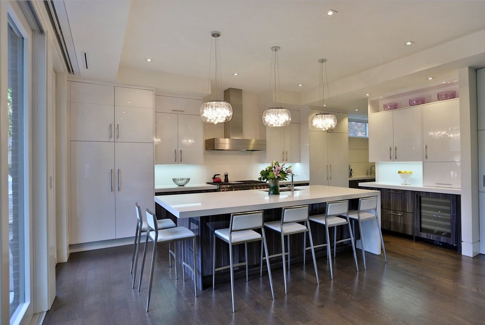 Mittelgroße Moderne Wohnküche in L-Form mit Unterbauwaschbecken, flächenbündigen Schrankfronten, weißen Schränken, Küchenrückwand in Weiß, Küchengeräten aus Edelstahl, dunklem Holzboden und Kücheninsel in Toronto