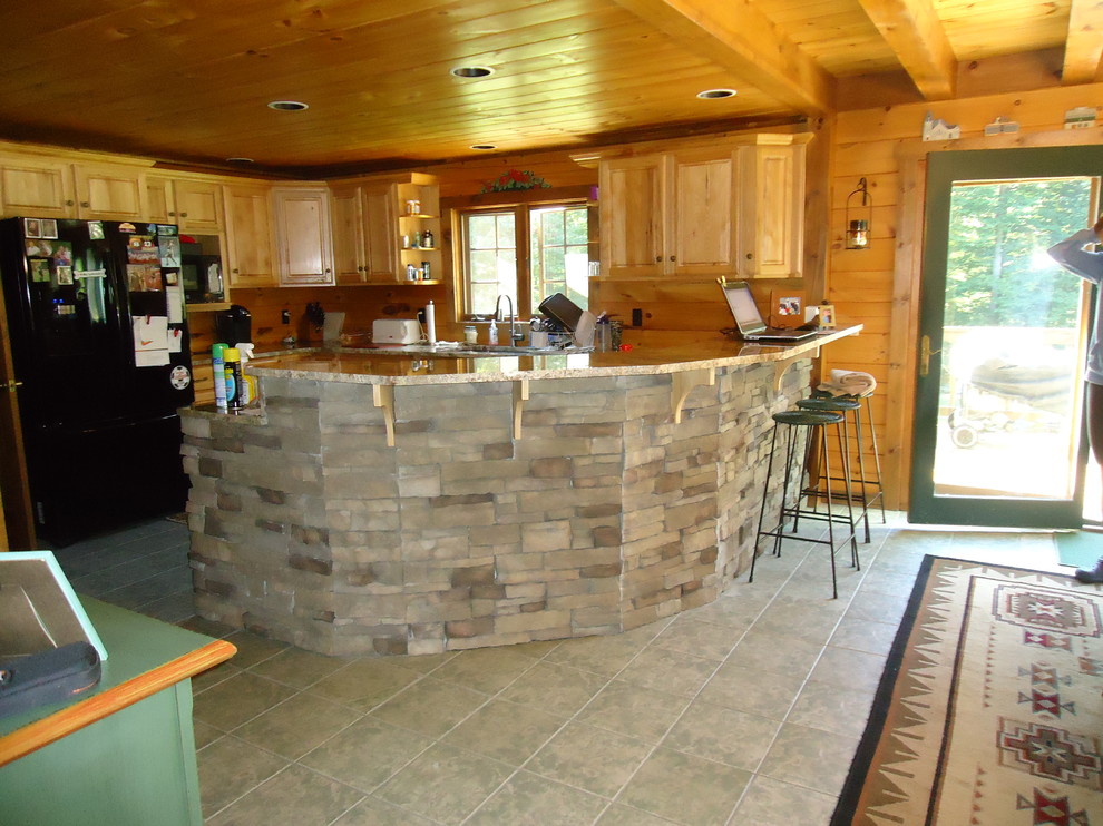 Inredning av ett rustikt mellanstort kök, med en undermonterad diskho, luckor med upphöjd panel, skåp i ljust trä, bänkskiva i koppar, svarta vitvaror, klinkergolv i keramik och en halv köksö