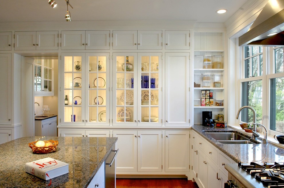 This is an example of a traditional kitchen in Cincinnati with glass-front cabinets and granite worktops.