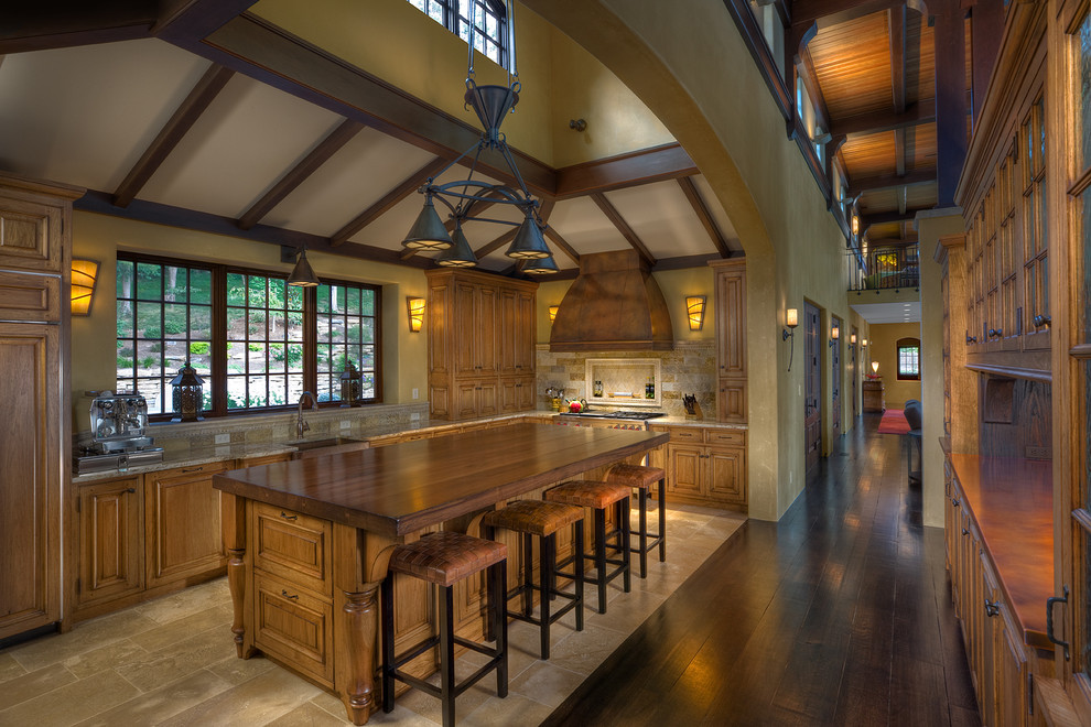Example of a tuscan kitchen design in Cincinnati with raised-panel cabinets and wood countertops
