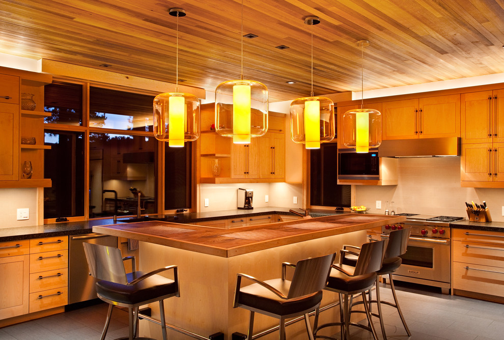 Example of a mountain style kitchen design in Sacramento with medium tone wood cabinets and stainless steel appliances