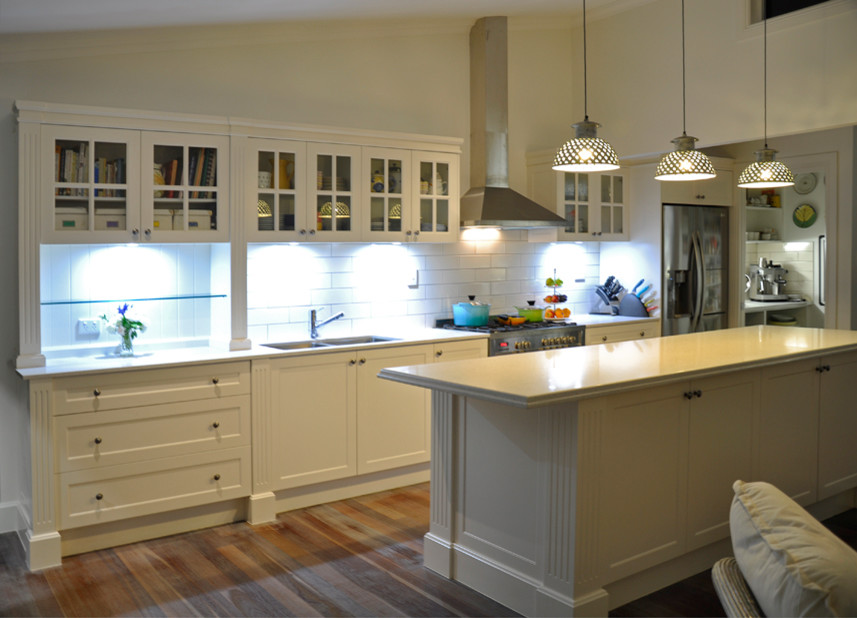Immagine di una cucina chic con ante in stile shaker, ante bianche, top in granito, paraspruzzi bianco, paraspruzzi con piastrelle in pietra e elettrodomestici neri
