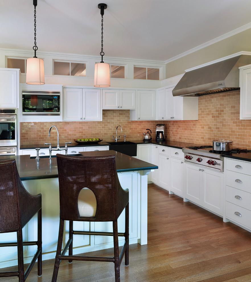 This is an example of a traditional kitchen in Boston with stainless steel appliances and metro tiled splashback.