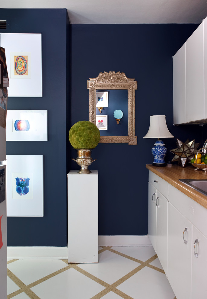 Example of an eclectic kitchen design in DC Metro with wood countertops, a drop-in sink, flat-panel cabinets and white cabinets