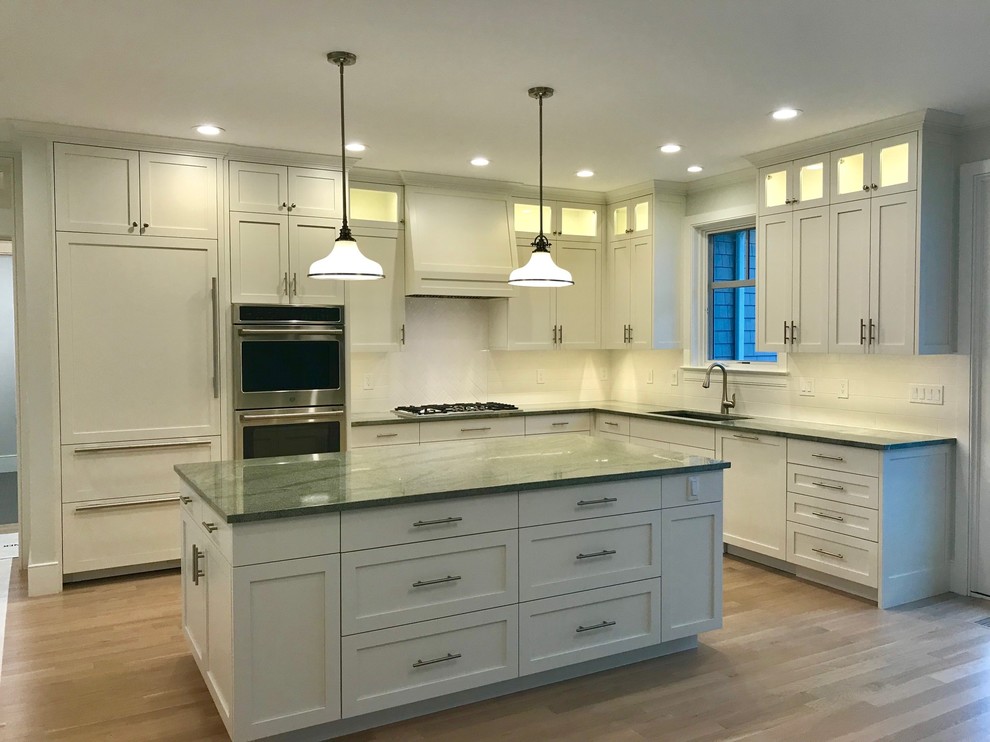 Eat-in kitchen - transitional light wood floor eat-in kitchen idea in Bridgeport with shaker cabinets, white cabinets, granite countertops, white backsplash, subway tile backsplash, stainless steel appliances, an island and green countertops