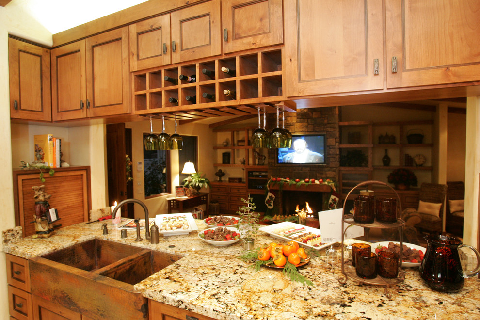 Imagen de cocina comedor de estilo americano de tamaño medio con fregadero sobremueble, armarios con paneles con relieve, puertas de armario de madera oscura, encimera de granito, salpicadero multicolor, salpicadero de losas de piedra, electrodomésticos de acero inoxidable, suelo de madera clara y una isla