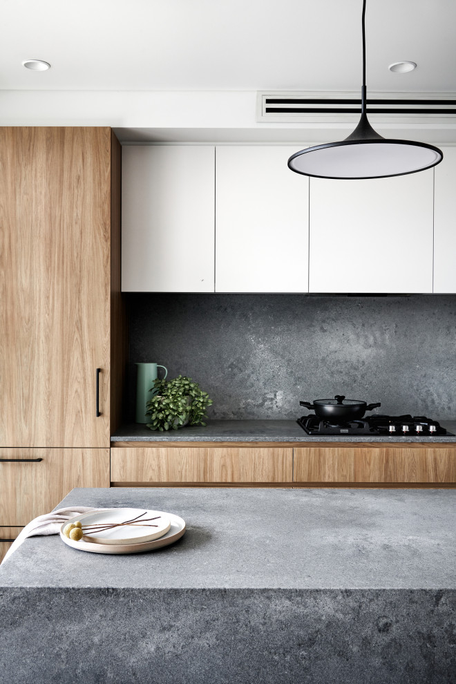 Inspiration för ett mellanstort skandinaviskt grå linjärt grått kök och matrum, med en undermonterad diskho, släta luckor, skåp i mellenmörkt trä, bänkskiva i kvarts, grått stänkskydd, svarta vitvaror, mörkt trägolv, en köksö och brunt golv