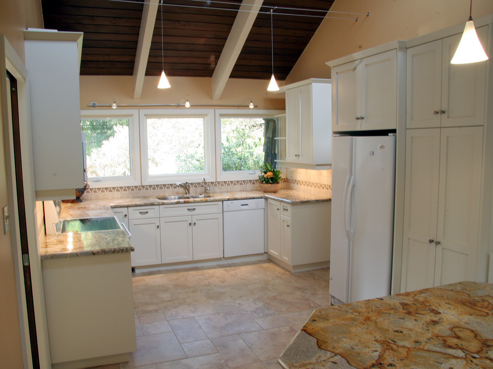 Foto på ett vintage kök, med en undermonterad diskho, luckor med infälld panel, vita skåp, granitbänkskiva, beige stänkskydd, stänkskydd i mosaik och vita vitvaror