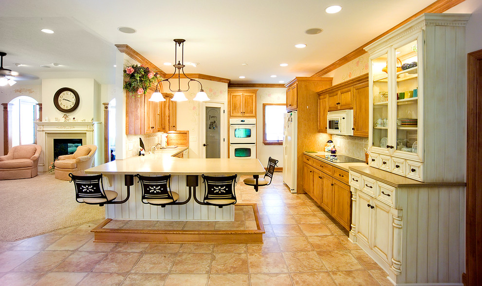 Example of a mid-sized classic ceramic tile eat-in kitchen design in Salt Lake City with an undermount sink, distressed cabinets, solid surface countertops, beige backsplash, ceramic backsplash, white appliances and an island