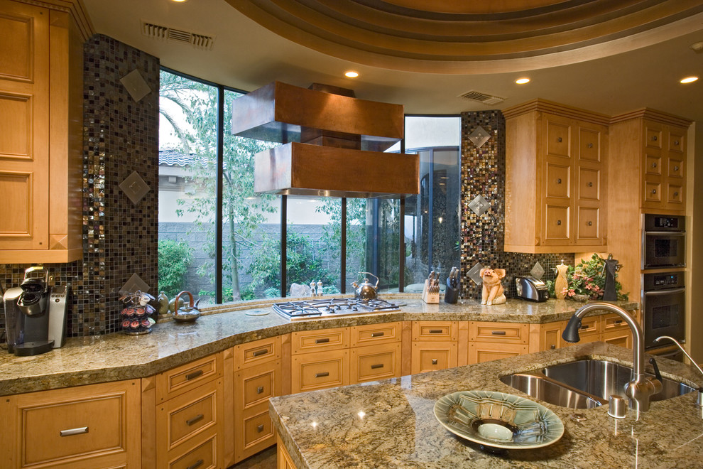 Inredning av ett amerikanskt mycket stort brun brunt kök, med en dubbel diskho, skåp i mellenmörkt trä, flerfärgad stänkskydd, stänkskydd i mosaik, rostfria vitvaror och flera köksöar