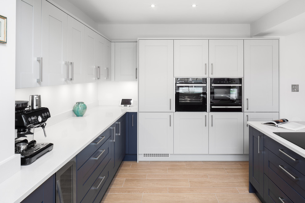 Large contemporary u-shaped open plan kitchen in Hertfordshire with a double-bowl sink, shaker cabinets, grey cabinets, quartz worktops, stainless steel appliances, ceramic flooring and an island.