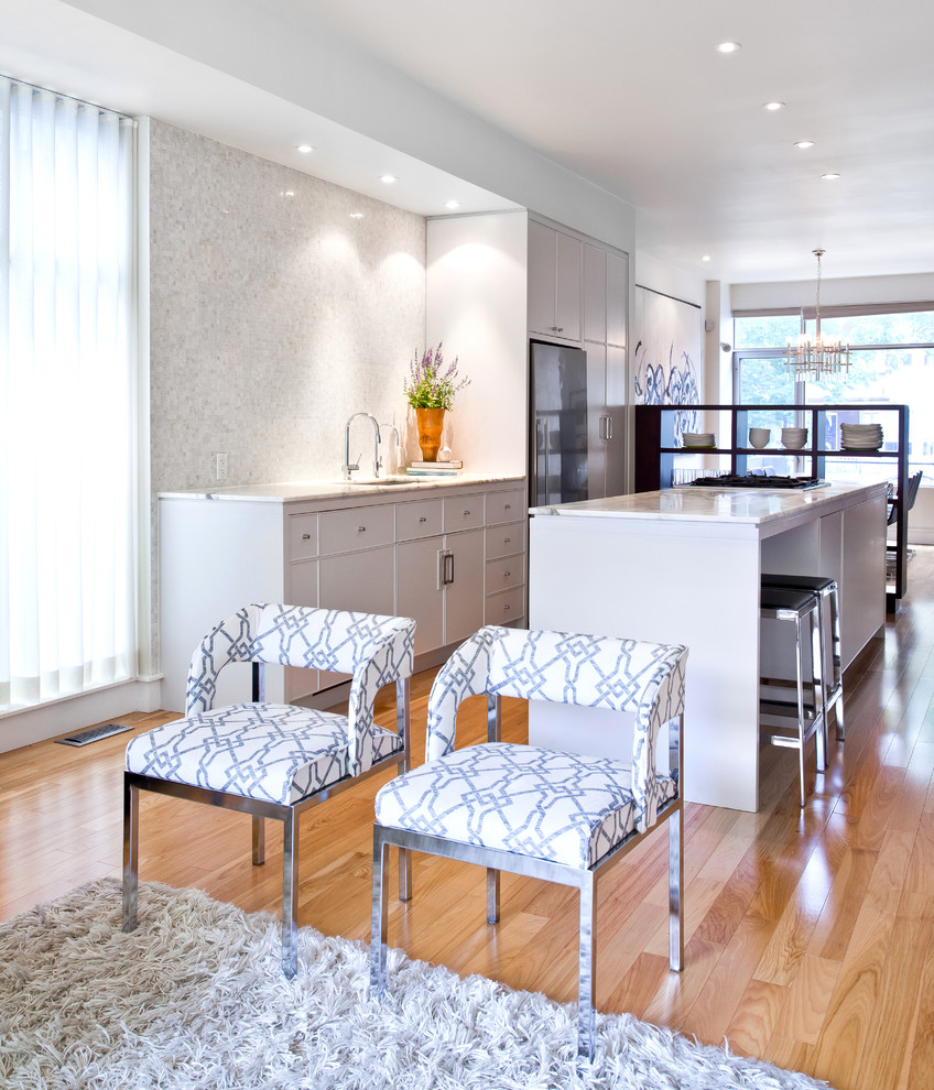 Modelo de cocina contemporánea abierta con armarios con paneles lisos, puertas de armario blancas y electrodomésticos de acero inoxidable