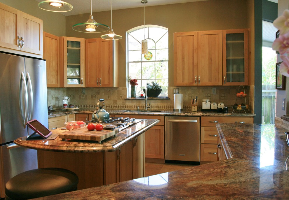 Exemple d'une cuisine tendance en U et bois clair avec un évier encastré, un placard à porte shaker, un plan de travail en granite, une crédence beige, une crédence miroir et un électroménager en acier inoxydable.