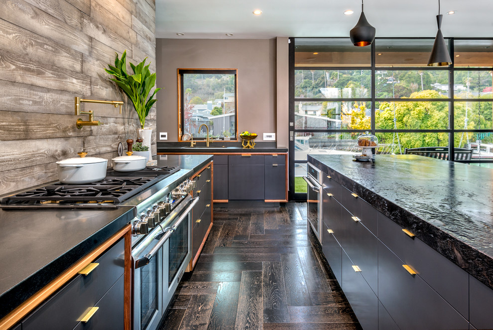 Modern inredning av ett stort kök, med en undermonterad diskho, släta luckor, grå skåp, marmorbänkskiva, brunt stänkskydd, stänkskydd i trä, rostfria vitvaror och en köksö