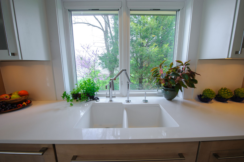 Foto di una cucina minimal di medie dimensioni con lavello sottopiano, ante in legno chiaro, top in quarzo composito, paraspruzzi bianco e paraspruzzi in lastra di pietra