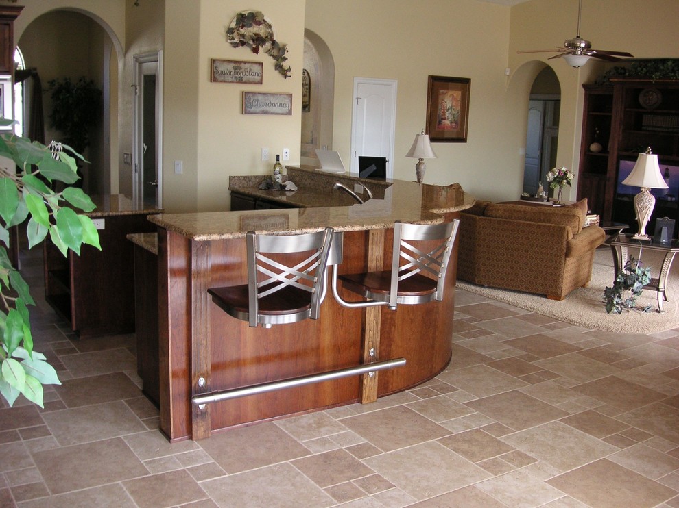 Esempio di una cucina classica di medie dimensioni con lavello da incasso, top in granito, elettrodomestici in acciaio inossidabile, pavimento con piastrelle in ceramica e penisola