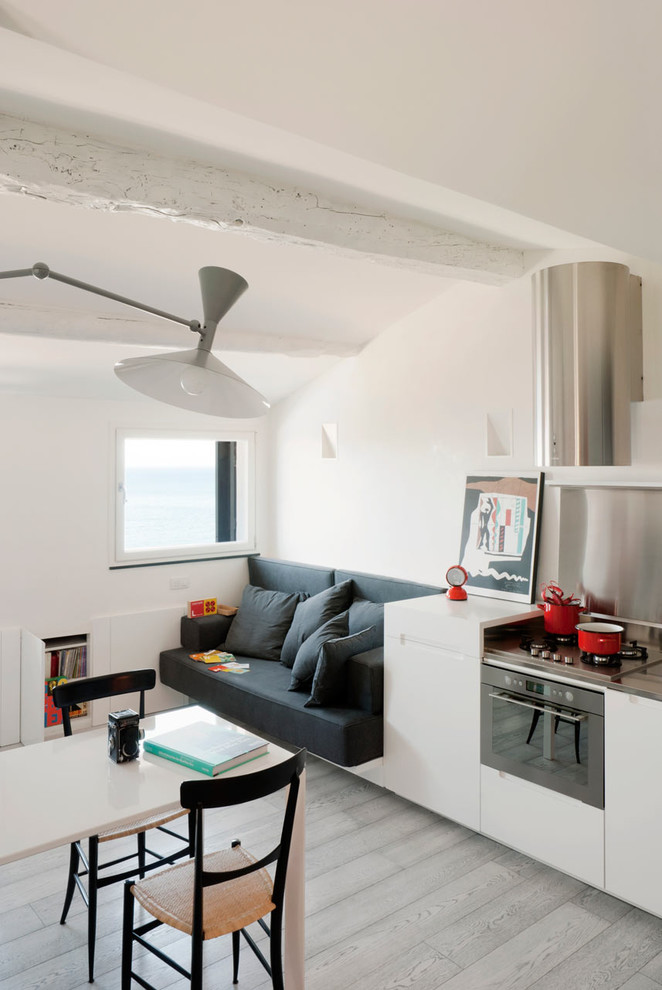 Immagine di una cucina abitabile contemporanea con ante lisce, ante bianche e paraspruzzi con piastrelle di metallo