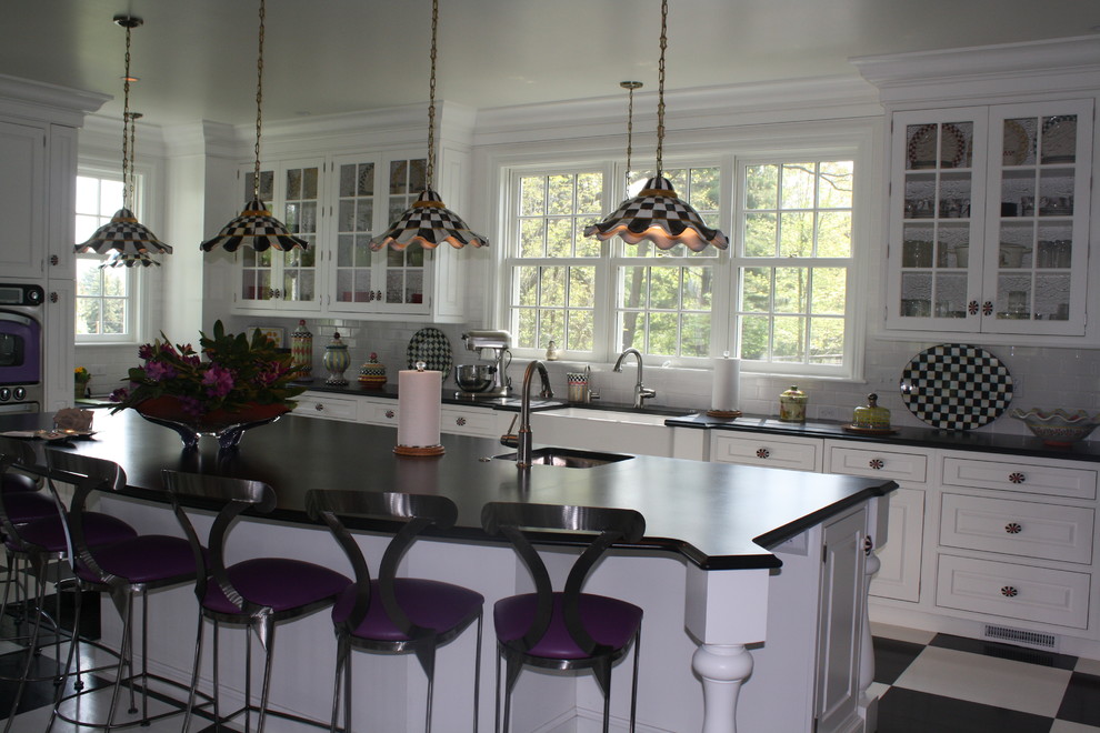 Inredning av ett eklektiskt stort kök, med en rustik diskho, luckor med upphöjd panel, vita skåp, granitbänkskiva, vitt stänkskydd, stänkskydd i tunnelbanekakel, målat trägolv och en köksö
